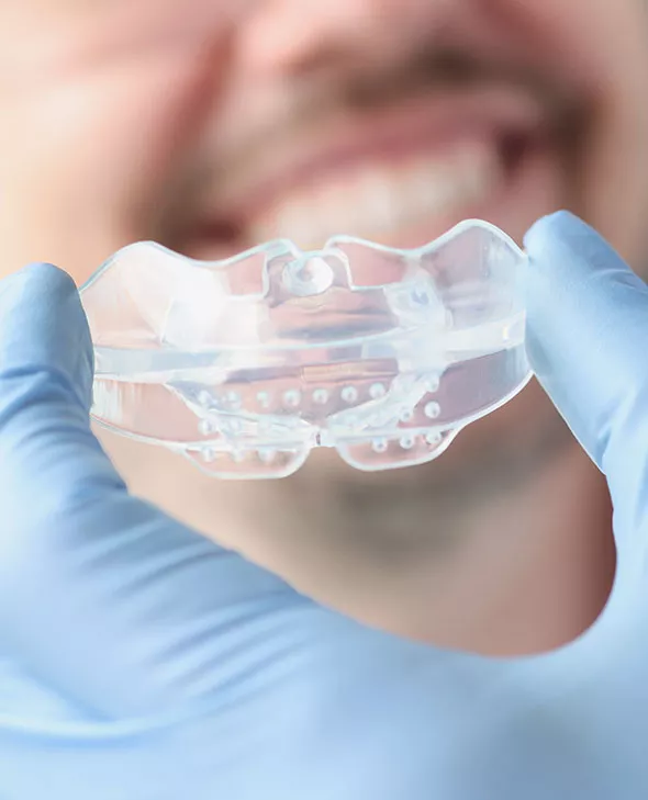 Close up of TMJ sleeping appliance with patient in background